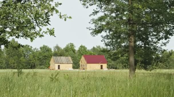 Video 1080p - Nuevas casas rurales de madera se construyen en un campo — Vídeos de Stock