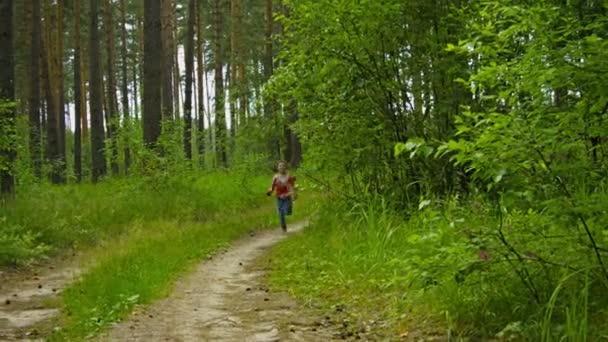 Vidéo 1080p - Joyeux enfant courant le long de la route dans une forêt d'été 