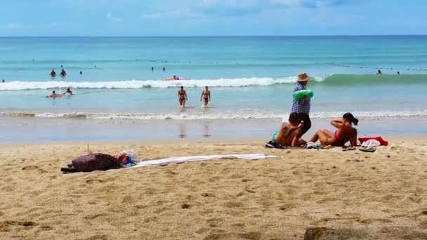 Патонг. Фьюкет. THAILAND - CIRCA NOV 2014: Туристы отдыхают на пляже Патонг на Пхукете. Таиланд и местные продавцы полотенец и сувениров — стоковое видео