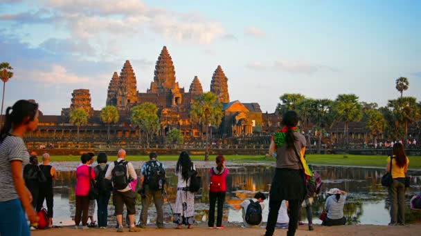 Angkor. Kambodża-Circa Dec 2013: pięć wież Angkor Wat w ostry kontrast z częściowo pochmurno. błękitne niebo. Turyści przechodzą robić zdjęcia i cieszyć się widokiem. Kambodża. Azji. — Wideo stockowe