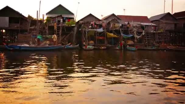 Tonle Sap Gölü. Kamboçya - Circa Aralık 2013: Tüm Kamboçya köyü doğrudan nehir suyunda kurulmuş yığınları üzerine inşa edilmiştir. Birçok el yapımı tekneler basit önünde demirlemiş. yükseltilmiş evler — Stok video
