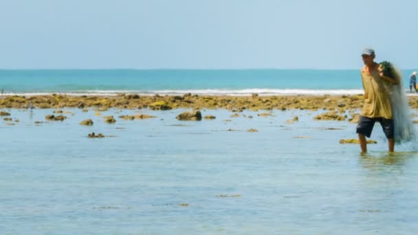 Phuket. Tayland - Circa Kas 2014: Deniz kuşları arka planda avlanırken onun net döküm için en iyi nokta arayan sığ sularda yerel balıkçı wades. Tayland. Asya. — Stok video