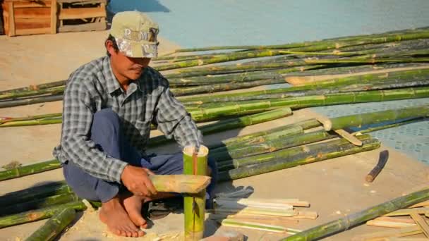 INLE LAKE. MYANMAR - CIRCA JAN 2014 : L'homme local traite les troncs de bambou — Video