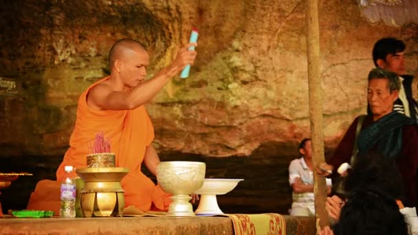 PHNOM KULEN. CAMBODIA - CIRCA DEC 2013: monaco buddista in paramenti tradizionali arancioni che esegue rituali religiosi per adoratori in Cambogia. Asia . — Video Stock