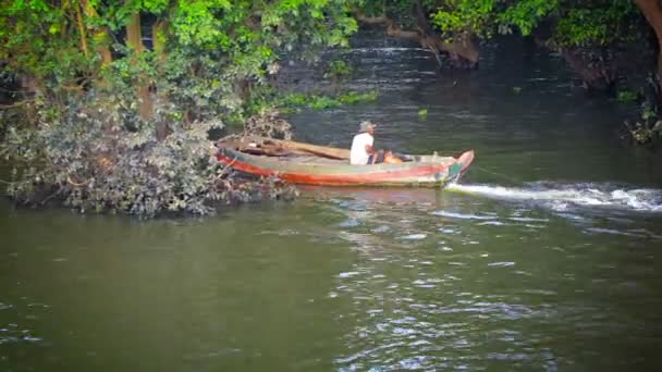 TONLE SAP LAKE. CAMBODIA - CIRCA DEC 2013: Local boatman towing logs down the river in his handmade wooden motorboat. Tourists passing in the opposite direction in a passenger boat. Cambodia. Asia — Stock Video