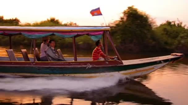 TONLE SAP LAKE. CAMBODIA - CIRCA DEC 2013: Local boatman cruising quickly down the river in his handmade. wooden. motorized passenger boat with two passengers onboard. — Stock Video
