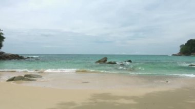 Palmiye ağaçları olmadan küçük tropikal plaj. Sadece kum ve taş