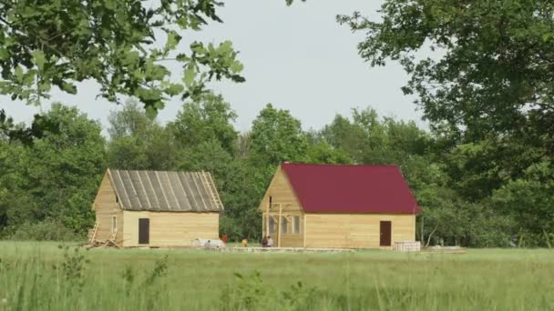 Nizjni Novgorod. Rusland - Circa Jun 2014: Het landelijke huizen bouwproces onder het bos — Stockvideo