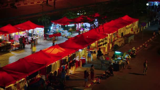 Vientiane. Laos - Circa Dec 2013: Alışveriş yapanlar Vientiane'deki halka açık gece pazarının iyi Aydınlatılmış satıcı standlarını taradılar. Laos. — Stok video