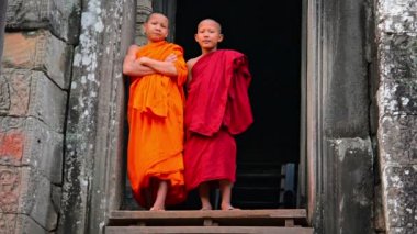 Siem Reap. Kamboçya - Circa Aralık 2013: Genç. Budist rahipler. Kamboçya Bayon Tapınağı'nda eski bir kapı da ayakta.