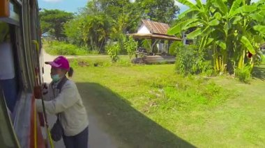 Tayland - Circa Aralık 2013: Kadın otobüs kondüktörü bir yolcu için yol yapar ve o karaya çıkarken onu veda selamlıyor.