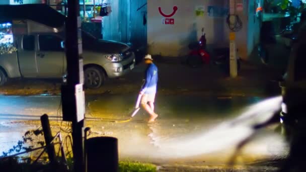 카 말라. 푸 켓. 태국 - 2014년 11월 경: 카말라의 도로에서 진흙을 씻기 위해 유조선 트럭에서 강력한 호스 분무기를 사용하는 지역 주민. 태국. — 비디오