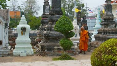 Yaşlı keşiş onun geleneksel. Ayutthaya Wat Phanan Choeng dışında stupas ve türbeler arasında gezinen turuncu bornoz. Tayland