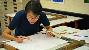 Yerel sanatçı geleneksel bir sanat eseri yaratmak için alışılmadık bir araçla serbest çizim. Tjanting.
