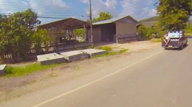 Tayland - Circa Aralık 2013: Bir otobüsün penceresinden çekildi. içme suyu şişeleri ile yüklü eski bir pikap kamyonun kargo yatağında tek bir yolcu sürmek.