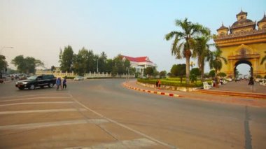 Vientiane. Laos - Circa Aralık 2013: Vientiane güneşli bir günde Patuxai anıt trafik daire sabah trafiği. Laos.