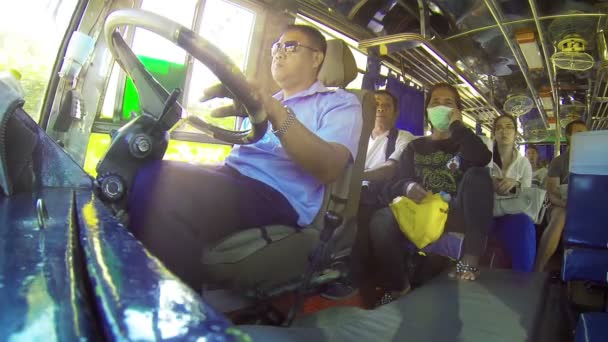 HUAY HAI. LAOS - CIRCA DIC 2013. Foto de bajo ángulo de un conductor de autobús muy relajado y varios pasajeros que viajan a lo largo de una carretera rural en Laos — Vídeos de Stock