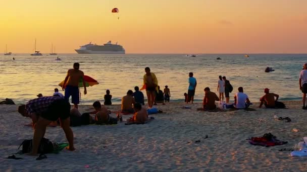 PATONG. PHUKET. THAILAND - CIRCA JAN 2015: Turistas desfrutam de muitas formas de recreação enquanto o sol se põe em Patong Beach. um destino de viagem muito popular . — Vídeo de Stock