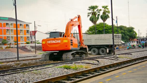 A sínágyon dolgozó hidraulikus kotrógép. végez karbantartást a vasútvonal Lopburi állomás Thaiföldön. hanggal. — Stock videók