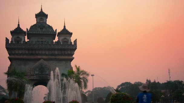 ВЕНТЬЯН. ЛАОС - CIRCA DEC 2013: Patuxai Arch. военный мемориал с его фирменными фонтанами. стоит частично силуэт против затемнения. закат во Вьентьяне. Лаос . — стоковое видео