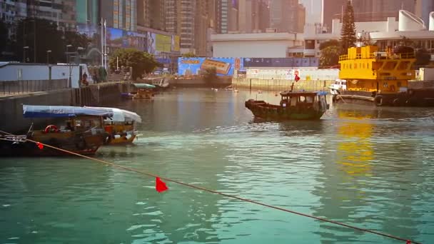 Hong Kong'da. Çin - Circa Jan 2015: Hong Kong şehir ticaret bölgesinde yolcu almak için bir kanal boyunca yanaşma küçük feribot tekneleri. — Stok video