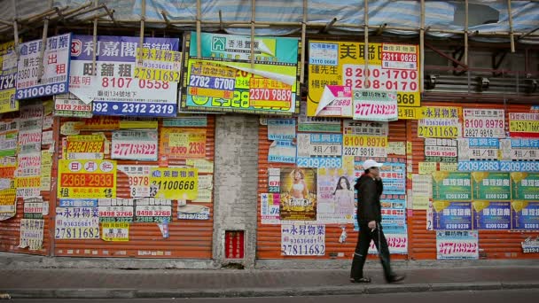 HONG KONG. CHINA - CIRCA ENE 2015: Paredes y puertas de seguridad de acero enrolladas en un local. mercado público. enyesado encima con muestras comerciales de la publicidad . — Vídeo de stock