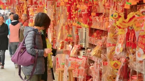 ГОНКОНГ. Китай - CIRCA JAN 2015: Покупатели просматривают новогодние украшения из ларька на открытом рынке в центре Гонконга . — стоковое видео