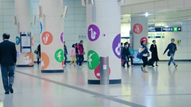 Hong Kong şehir merkezindeki bir metro istasyonunda bilerek yürüyen yolcular.