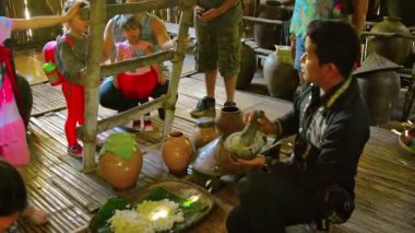 Tur rehberi geleneksel hakkında konuşuyor. Kota Kinabalu yakınlarındaki bir köyde bir eğitim merkezinde pirinç şarabı yerli üretim.