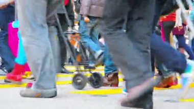 Şehir yaya trafiğinin bacakları ve ayakları. şehir ticaret bölgesinde sarı çizgili bir yaya geçidinde büyük bir caddeyi geçerken.
