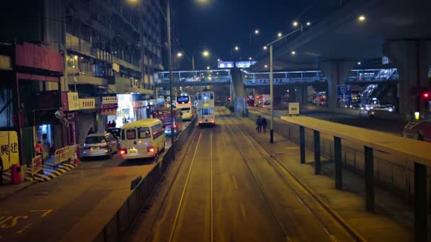 Night time traffic at a transit stop along an urban street in downtown Hong Kong. — Stock Video