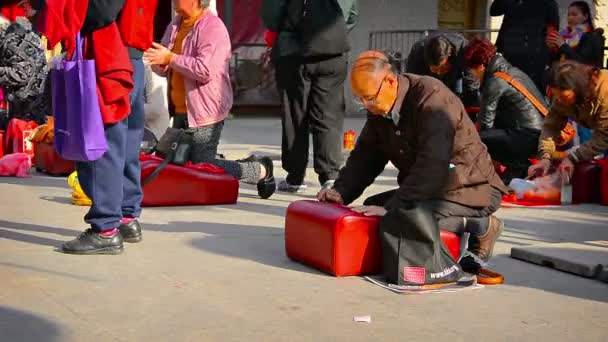 Budist ibadet edenler yastıklar üzerinde diz çöküp Hong Kong'daki Wong Tai Sin Tapınağı'nda bir sunak önünde dua ederler.. — Stok video