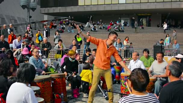 L'uomo del posto si diverte a guidare i turisti nel fare ritmi con strumenti a percussione vicino al molo. Tamburo cerchio spettacolo. Facilitatore: Channon Liu — Video Stock