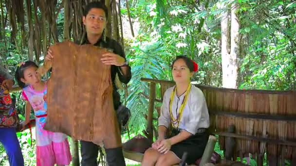 Professional tour guide explains native methods for producing traditional handicrafts such as a vest made from natural fibers. — Stock Video