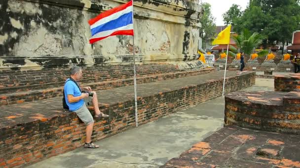 En uppfriskande BRIS kyler turister när de promenerar genom en uråldrig. Buddhistiska tempel innergård i Ayutthaya Historical Park i Thailand. — Stockvideo