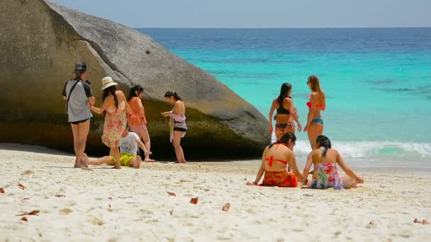 Turister koppla av i Leigh av en massiv stenblock bredvid det kristallklara vattnet i Andamansjön. — Stockvideo