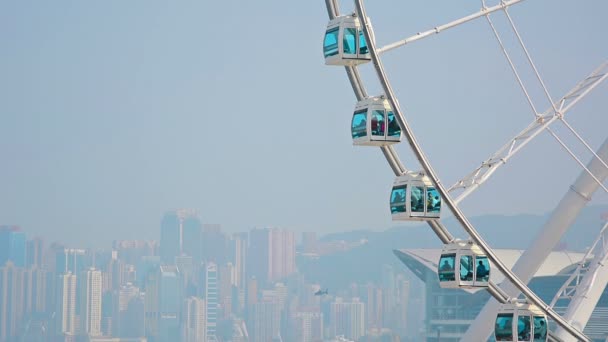 Enorme noria con un horizonte de la ciudad en el fondo — Vídeo de stock