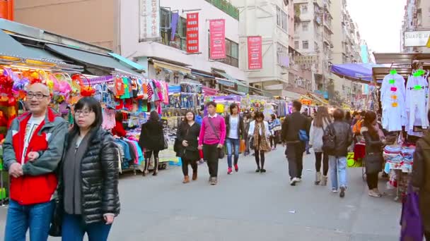 Einkäufer schlendern durch ein geschäftiges. Draußen. Innenstadtmarkt. in Hongkong. Stöbern an den verschiedenen Ständen. — Stockvideo