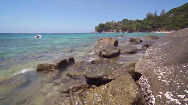 Gummi jolle förankrade utanför en stenig tropisk strand — Stockvideo