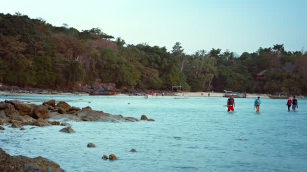 Turistas vagando na água rasa na maré baixa da tarde na ilha Phi Phi, na Tailândia. Sudeste Asiático . — Vídeo de Stock