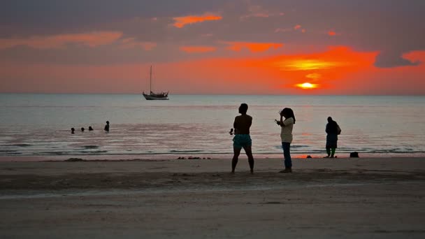 Turistas enyoying um pôr-do-sol romântico sobre um popular. praia tropical em Langkawi. Malásia — Vídeo de Stock