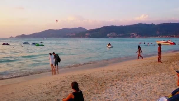 Patong. Phuket. Thajsko-circa Jan 2015: Plážoví Gozáci si vychutnávají písek a moře na pláži Patong, když slunce zapadá přes obzor. — Stock video