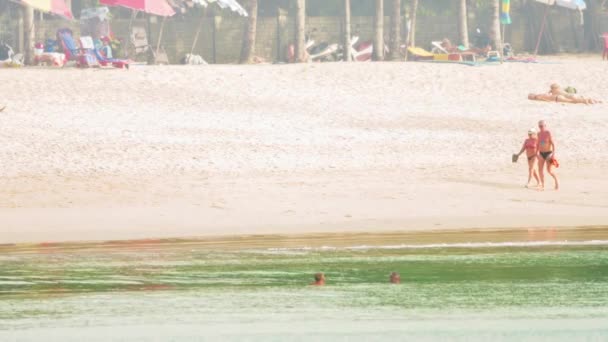 Камала. Фьюкет. ТАИЛАНД - CIRCA DEC 2014: Иностранные туристы наслаждаются солнечным днем на пляже с белым песком . — стоковое видео