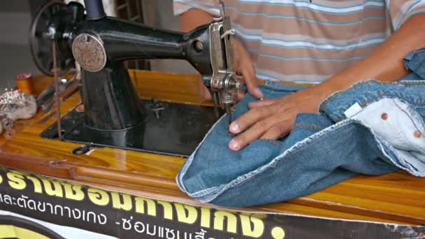 Bangkok. Thaiföld-Circa február 2015: a helyi munkavállaló megváltoztatása Jeans egy régi varrógép Bangkokban. Thaiföld — Stock videók