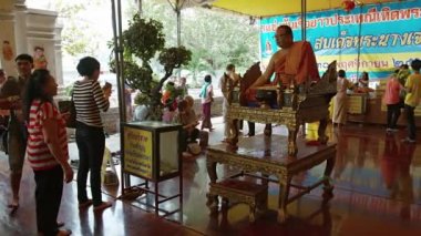 Ayuthaya. Tayland - Circa Feb 2015: Ayutthaya'daki Wat Phanan Choeng'de bereket ve öğüt sunan üst düzey bir keşişe adaklar sunan Budist ibadet edenler. Tayland.