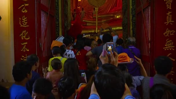 Ayutthaya. thailand - ca. feb 2015: lokale und touristen in zu sehen enorm. vergoldete Buddha-Statue im wat phanan choeng im historischen Park von Ayutthaya — Stockvideo