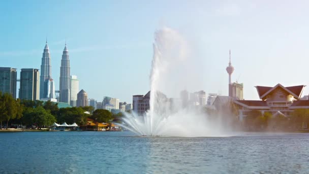 Fuente rociando el cielo en un parque de la ciudad — Vídeos de Stock