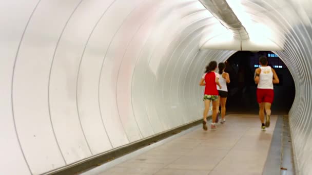 Бігунів, біг в обох напрямках через спеціальні тунель, призначені для пішоходів в центрі міста Сінгапур. Південно-Східна Азія. — стокове відео