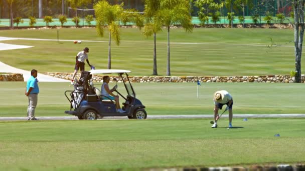 Turista élvezi a játékot a golf egy népszerű. gyönyörűen parkosított és karbantartott pálya Langkawi. Malajzia — Stock videók