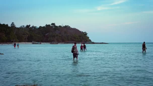 Los turistas vadeando a través de las aguas poco profundas en la marea baja. en la isla Phi Phi en Tailandia . — Vídeo de stock